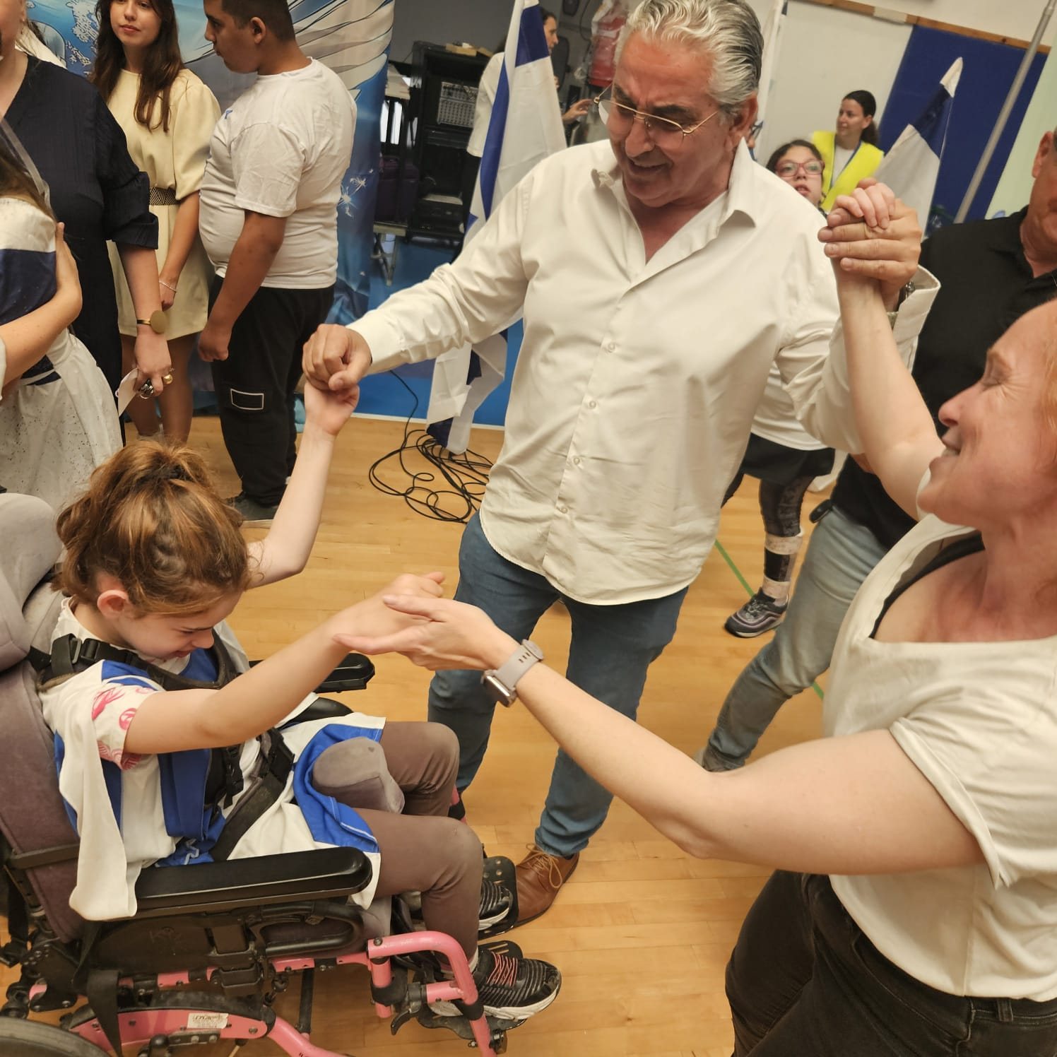 Mr. Chaim Broide, Mayor of Raanana, dances hand in hand with a student in a wheelchair